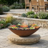 Arteflame fire bowl elevated on a separate stone pedestal in an outdoor terrace