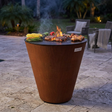 Arteflame ONE30 with food cooking on the outer cooktop and central grate over a live fire