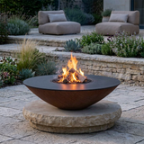 Arteflame used as a fire pit on a separate stone pedestal at dusk