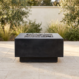 Cubo concrete fire bowl in a softly lit limestone courtyard