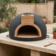 Frontal view of the Tonío brick pizza oven in an outdoor patio setting
