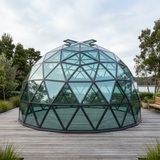 Patioza glass geodesic dome in a landscaped lakeside retreat